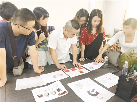 五邑大学产学研团队与丽明珠公司设计师一起探讨箱包设计。